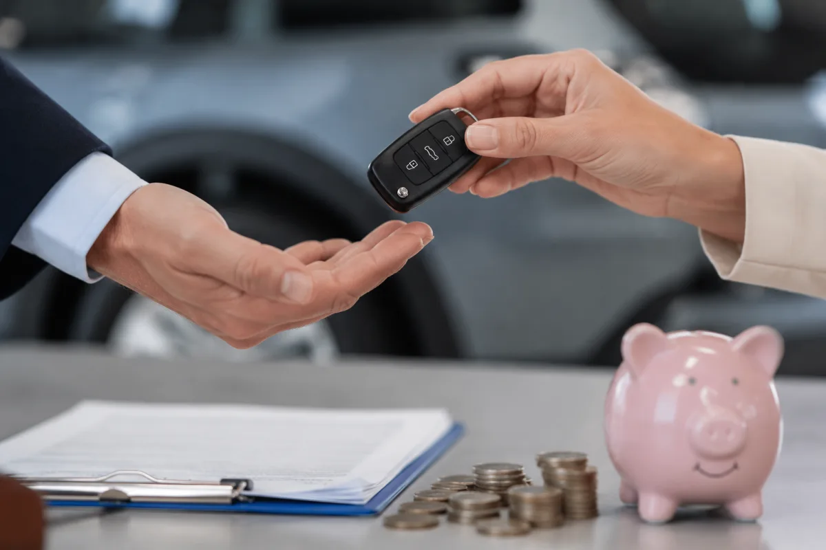 Aides pour l'achat d'une voiture électrique : ce que vous pouvez vraiment obtenir Main branchant un câble de recharge sur la prise d'une voiture électrique blanche en gros plan