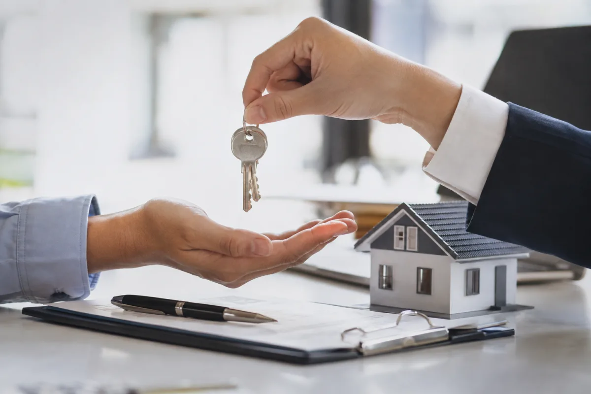 Main tenant un stylo sur un dossier complet de pièces justificatives locatives